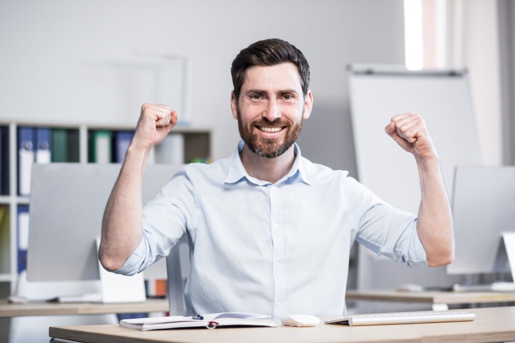 Portrait of a young successful man, office worker, manager, freelancer rejoices
