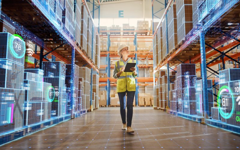 Futuristic Technology Retail Warehouse: Worker Doing Inventory W Futuristic Technology Retail Warehouse: Worker Doing Inventory Walks when Digitalization Process Analyzes Goods, Cardboard Boxes, Products with Delivery Infographics in Logistics, Distribution Center